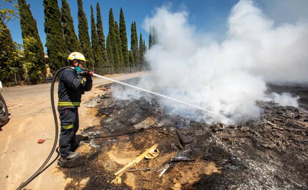 Un bombero de Granada apaga un incendio junto a la Circunvalación en una imagen e archivo./ALFREDO AGUILAR