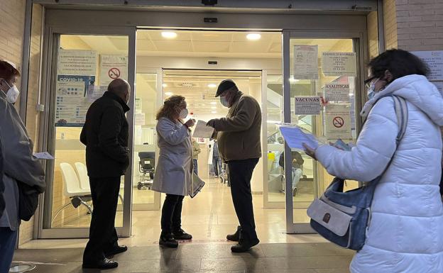 Una sanitaria guía a un paciente a las puertas de un centro de salud. /IVÁN ARLANDIS