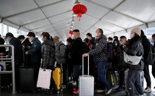 La gente camina con su equipaje en una estación de tren durante la fiebre anual del Festival de Primavera antes del Año Nuevo Lunar chino. /REUTERS
