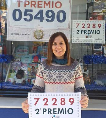 María Teresa, de la Papelería Jofi, posa con el cartel que anuncia que han dado un segundo premio de El Niño./IDEAL